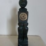 Unusual green wood figure of man holding Chinese coin
